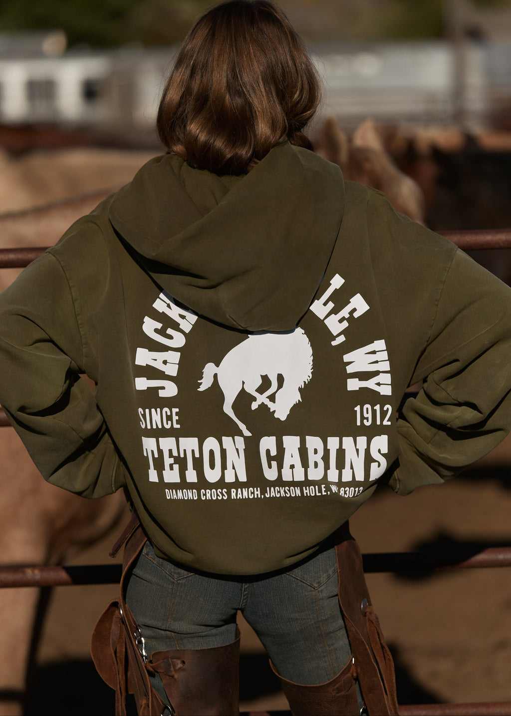 Army Green | Person wearing a green hoodie with branding in an outdoor setting